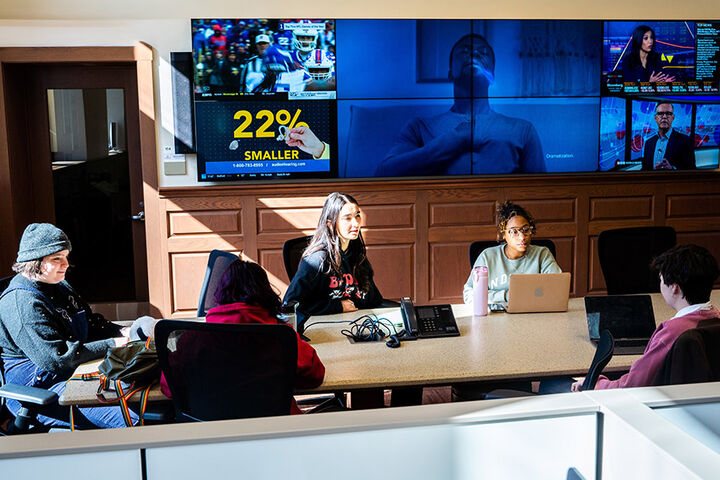 A group of students working together in a large conference room.